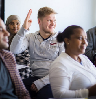 Student raising hand in class Student raising hand in class